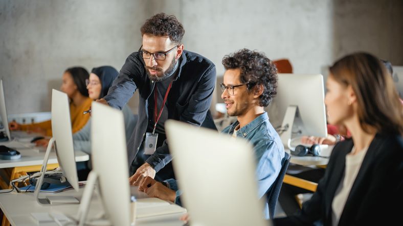 Instructor helping students with computers